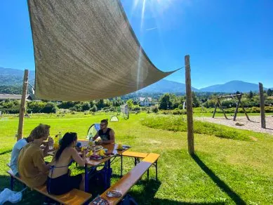 Gemeinsame Pause am Picknicktisch unter einem Sonnensegel
